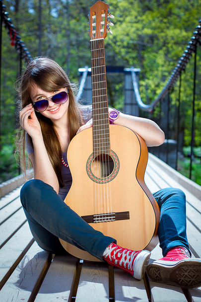 Girl with the guitar on the bridge - Foto, immagini