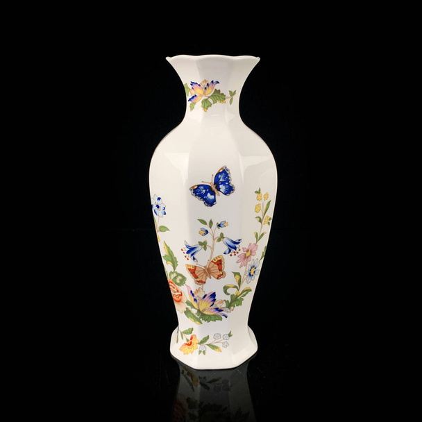 antieke porseleinen vaas met bloemmotief. handgemaakte vaas op zwarte achtergrond - Foto, afbeelding