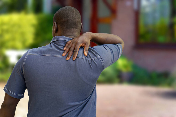 Afričtí muži trpící bolestí ramene, zánětem kloubů, artritidou na dvorku domu - Fotografie, Obrázek