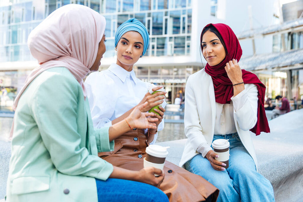 Multiethnic group of muslim girls wearing casual clothes and traditional hijab bonding and having fun outdoors - 3 arabic young girls - Fotó, kép