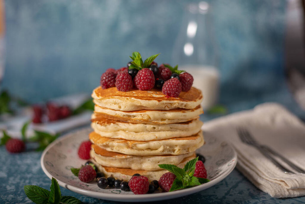 Delicious fluffy pancakes with berries and maple syrup - Photo, image