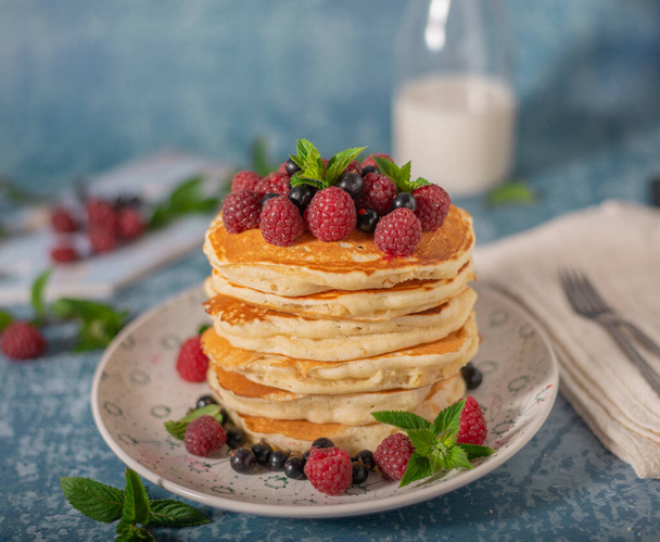 Delicious fluffy pancakes with berries and maple syrup - 写真・画像