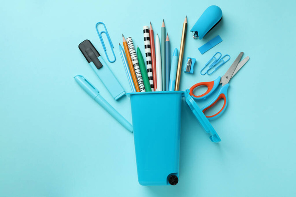 Holder in the form of trash can with stationery on blue background - Фото, изображение