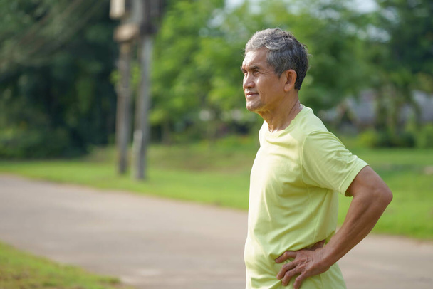 Yaşlı, emekli bir adam, yaşlılarda sağlık hizmeti kavramı olan parkta yapılan egzersizden sonra gelişigüzel ayakta duruyor.                                                                                                         - Fotoğraf, Görsel