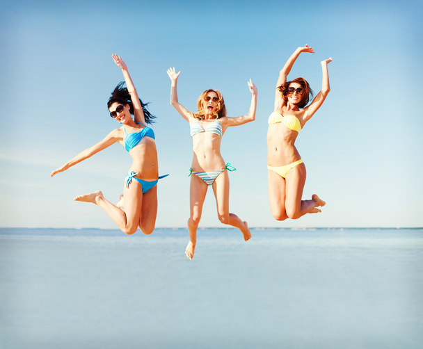 girls jumping on the beach - Foto, afbeelding