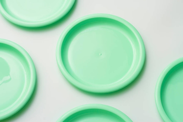 Plastic dishes in mint color on white background. - Photo, Image