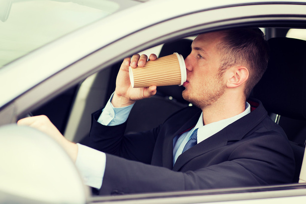 man drinking coffee while driving the car - Zdjęcie, obraz