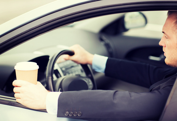 man drinking coffee while driving the car - Foto, Imagen