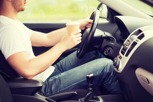 man drinking coffee while driving the car - Photo, image