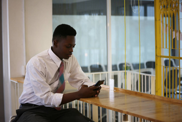giovane uomo d'affari afroamericano utilizzando il telefono cellulare in caffè. - Foto, immagini