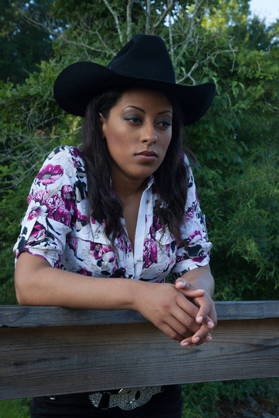 Pretty woman in a cowboy hat looking thoughtful - Foto, Imagem