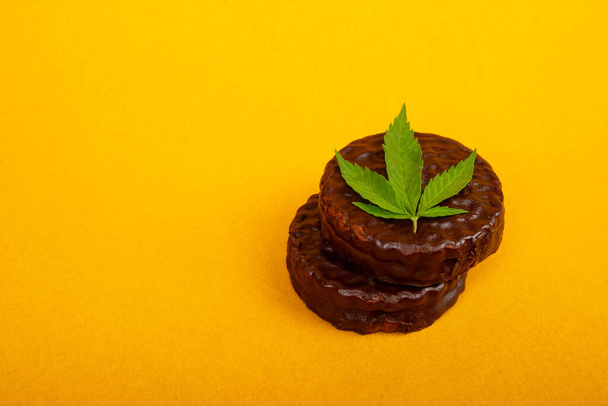 biscuits au chanvre, bonbons au chocolat au cannabis sur fond jaune - Photo, image