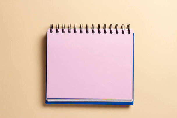 Cuaderno abierto con página rosa sobre un fondo delicado. - Foto, Imagen
