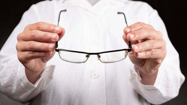 Optikerarzt schenkt einem Patienten eine Brille zur Verbesserung des Sehvermögens. - Foto, Bild