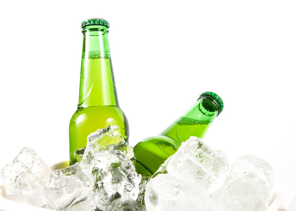Дві пляшки пива охолоджуються в кубиках льоду
 - Фото, зображення