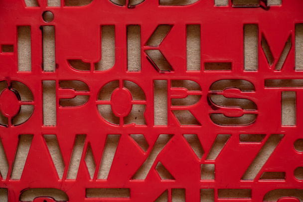 stencil rosso di plastica con lettere inglesi come sfondo, lettere inglesi - Foto, immagini