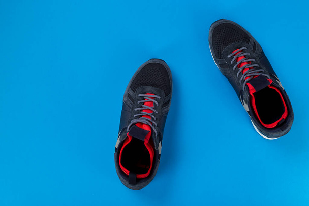 Pair of men's insulated sneakers close-up on a blue background. - Fotó, kép