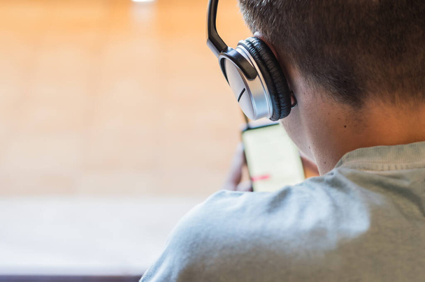 close-up van tiener in hoofdtelefoon luisteren naar muziek, spelen, leren online met smartphone.Technology concept - Foto, afbeelding