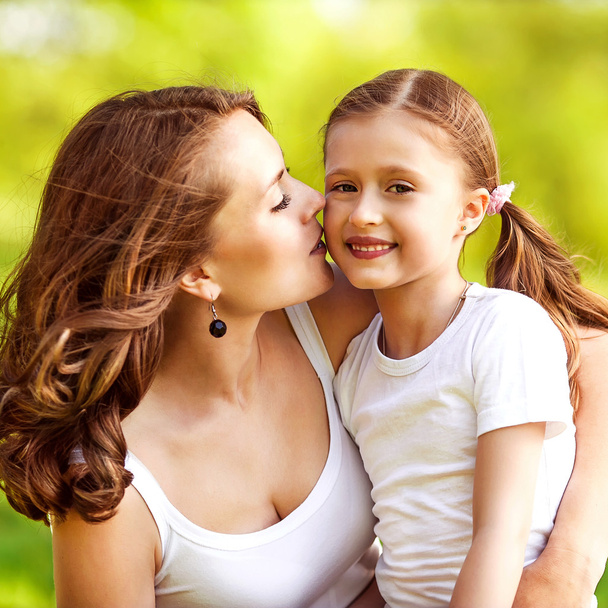mother and daughter hugging in love playing in the park - Foto, imagen