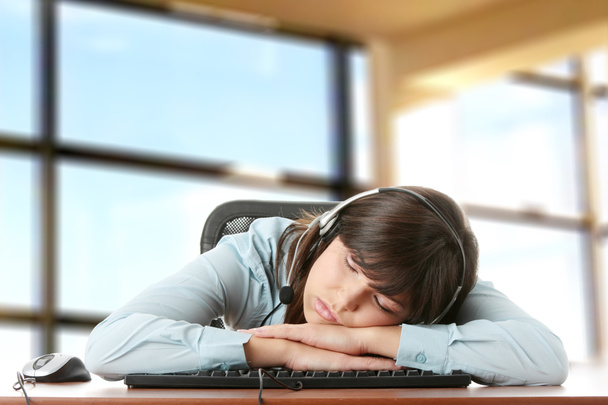 Young caucasian woman sleeping on keyboard - Foto, afbeelding