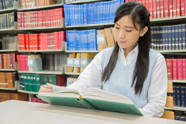 azjatyckich studentów czytania książki w bibliotece Uniwersytetu - Zdjęcie, obraz
