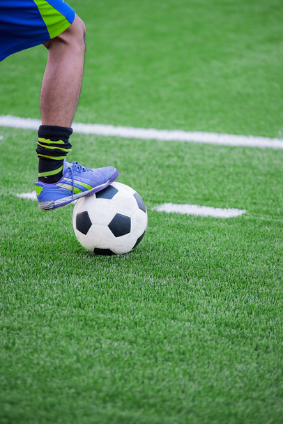 bir futbol topu stepping futbol oyuncunun ayak - Fotoğraf, Görsel