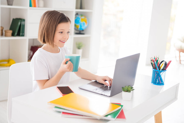 Foto retrato niña viendo lección en línea con el ordenador portátil beber té escribiendo respuesta - Foto, Imagen