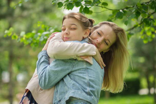 happy mother with her daughter hugging a teenager in the summer. Caring happy mother enjoy day with teenage girl child, laugh have fun. Mother giving her daughter advice. - Foto, Imagem