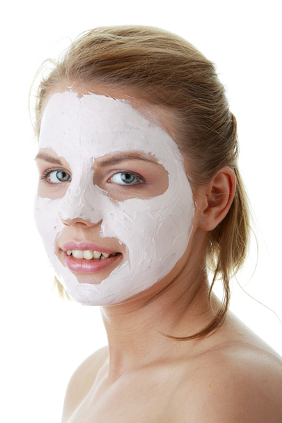 Cosmetics mask of clay on the young female face - Foto, afbeelding