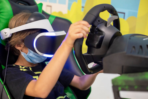 European boy kid child play virtual reality game wear VR glasses and explore alternative reality. Cyber space and virtual gaming, Playing with videogames joystick. - Photo, Image