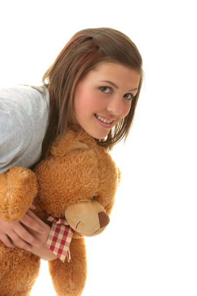 Beautiful teenager holding a teddy bear - isolated on white background - Foto, afbeelding