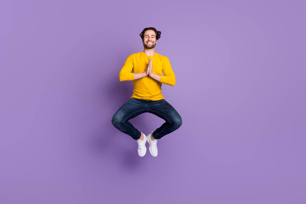 Full length body size photo smiling man in casual outfit jumping up practising yoga isolated pastel purple color background - Foto, afbeelding