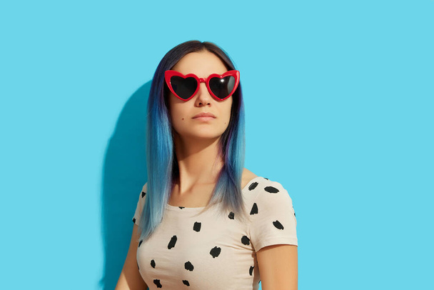 Mujer Hipster con pelo azul usando gafas de sol. Chica caucásica grave mirando hacia arriba - Foto, Imagen