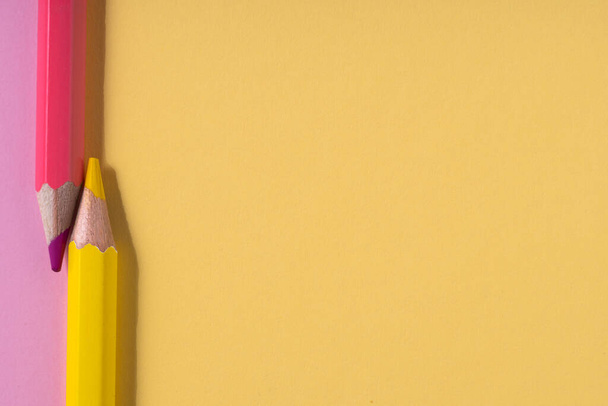 Vaaleanpunainen ja keltainen kyniä pastelli vaaleanpunainen ja keltainen kontrasti tausta. koulutus concept. top view.place tekstiä. - Valokuva, kuva