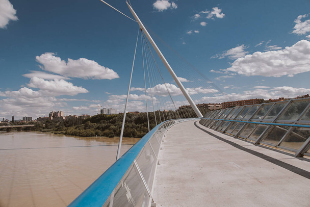 夏の日にスペイン・サラゴサのエブロ川に架かる美しい歩行者用吊り橋 - 写真・画像