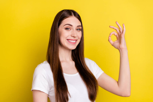 Profile side photo of young girl happy positive smile show okay sign deal alright perfect isolated over yellow color background - Foto, afbeelding