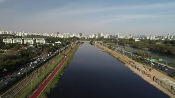 Pohled na Marginal Pinheiros s řekou Pinheiros a moderní budovy v Sao Paulu, Brazílie. - Záběry, video