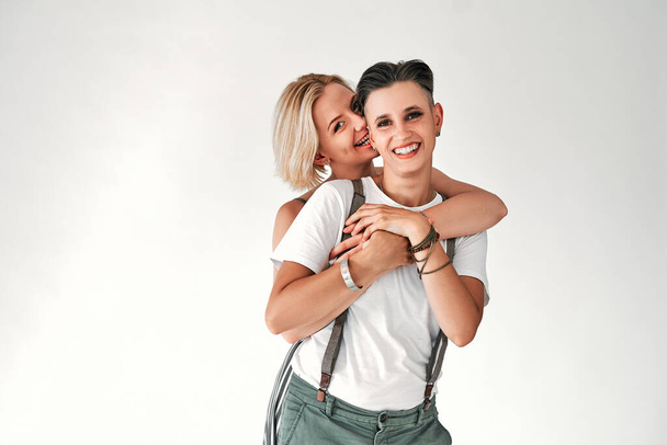 Cheerful lesbians embrace passionately and have fun together. Isolated white background. Copy space. - 写真・画像