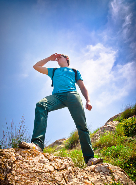 jovem homem saudável caminhadas nas montanhas olha para a distância
 - Foto, Imagem