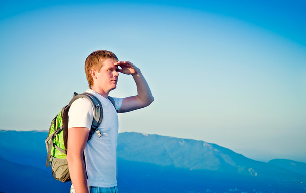 young guy is in the mountains and looks into the distance - Fotografie, Obrázek