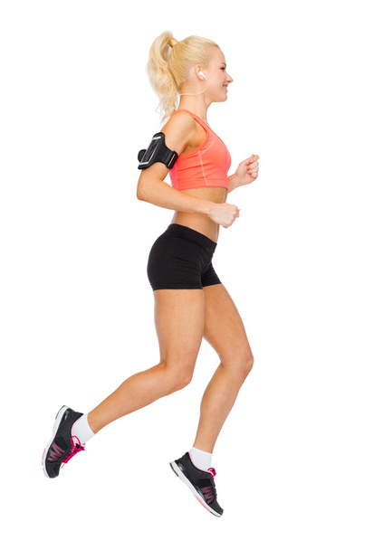 sporty woman running with smartphone and earphones - Foto, immagini