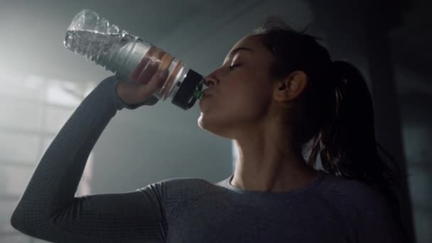 Spor şişesinden su içen sporcu kadın. Elinde şişe tutan kız. - Video, Çekim