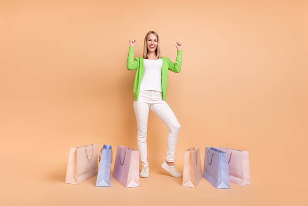 Full length body size view of attractive cheerful girl celebrating new bargain having fun isolated over beige pastel color background - Zdjęcie, obraz