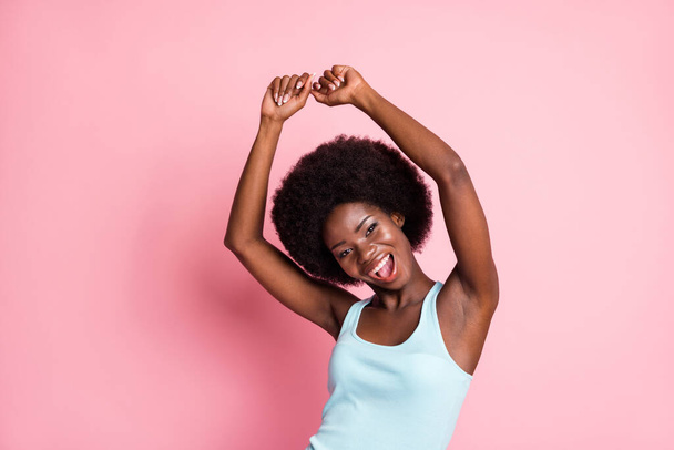Portrait of hooray brunette curly lady hands up dance wear blue top isolated on pink color background - Foto, Imagem