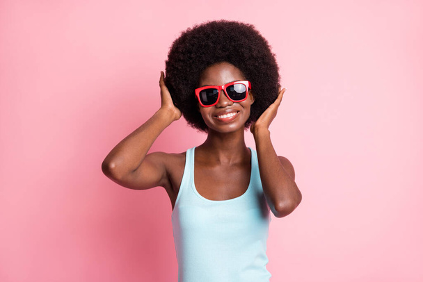 Photo of charming happy dark skin woman touch hair summer good mood isolated on pink color background - Φωτογραφία, εικόνα