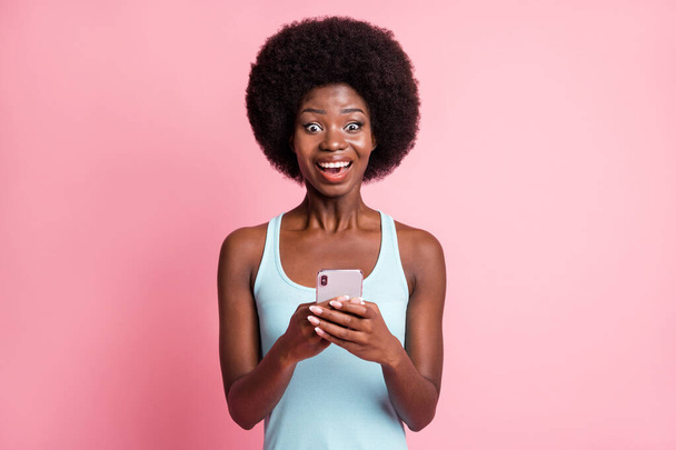 Photo of beautiful young dark skin woman hold phone news message social media isolated on pink color background - Fotó, kép