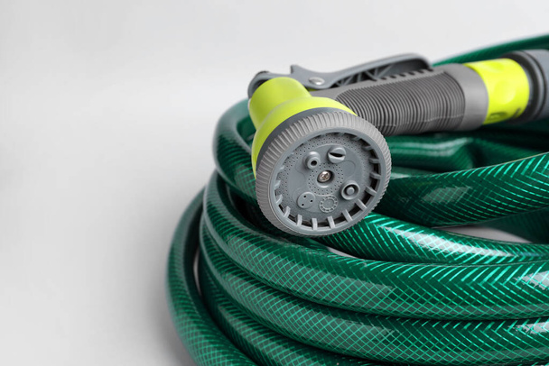Watering hose with sprinkler on light grey background, closeup. Space for text - Foto, immagini