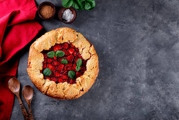 Homemade pie with strawberries on gray background top view, summer pastries with berries, photo with copy space for text - Fotografie, Obrázek