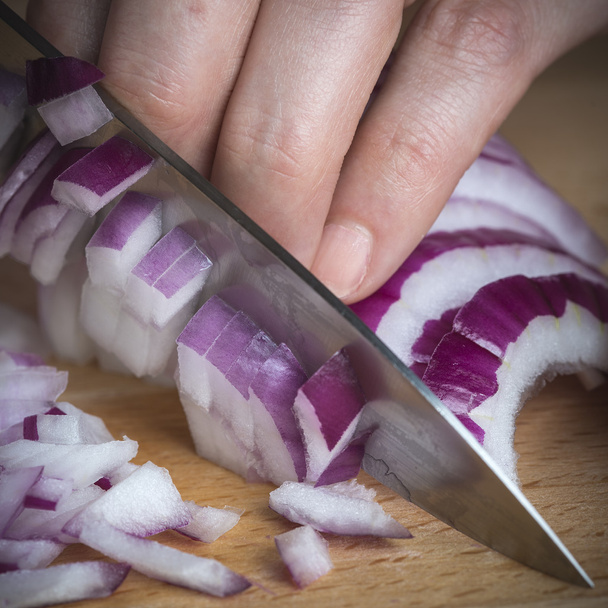 Chef choppig a red onion with a knife - Φωτογραφία, εικόνα