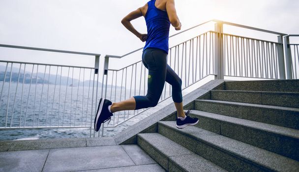 Healthy lifestyle fitness sports woman runner running on seaside trail - Valokuva, kuva